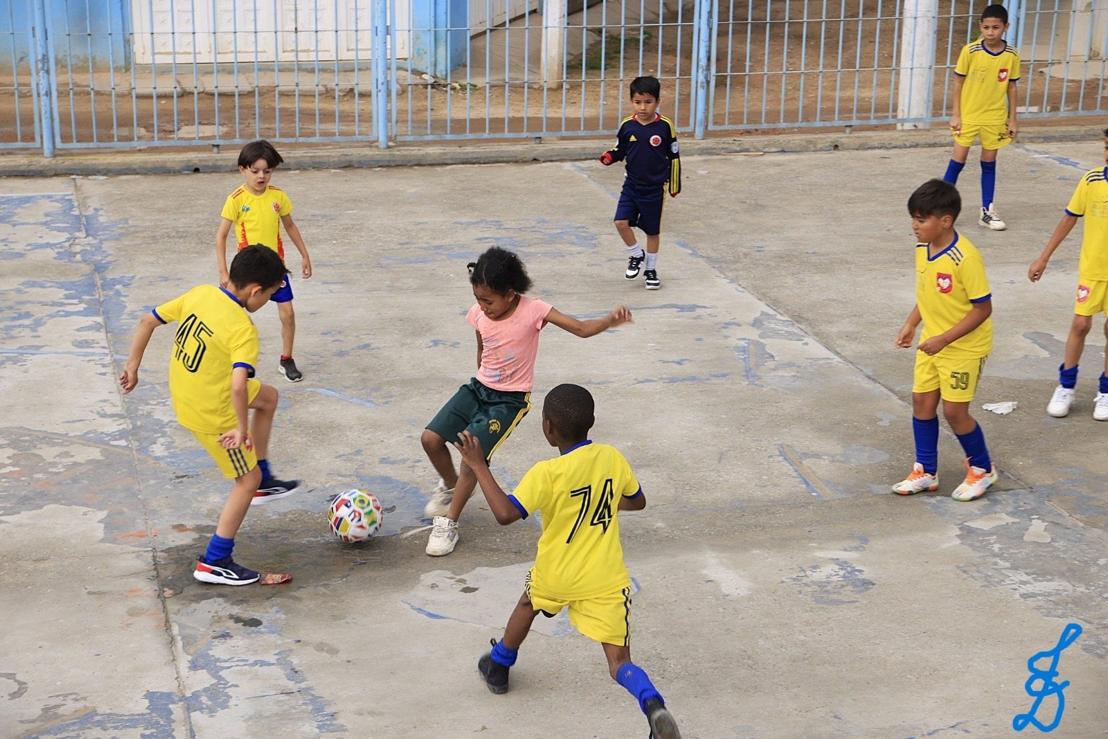 Niños jugando fútbol en la cancha